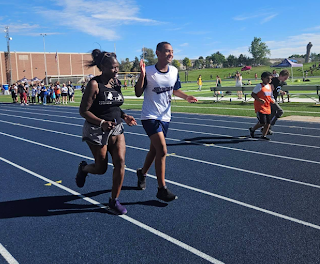 board secretary Gayla Charrier running alongside a Unified Sports student at a track event