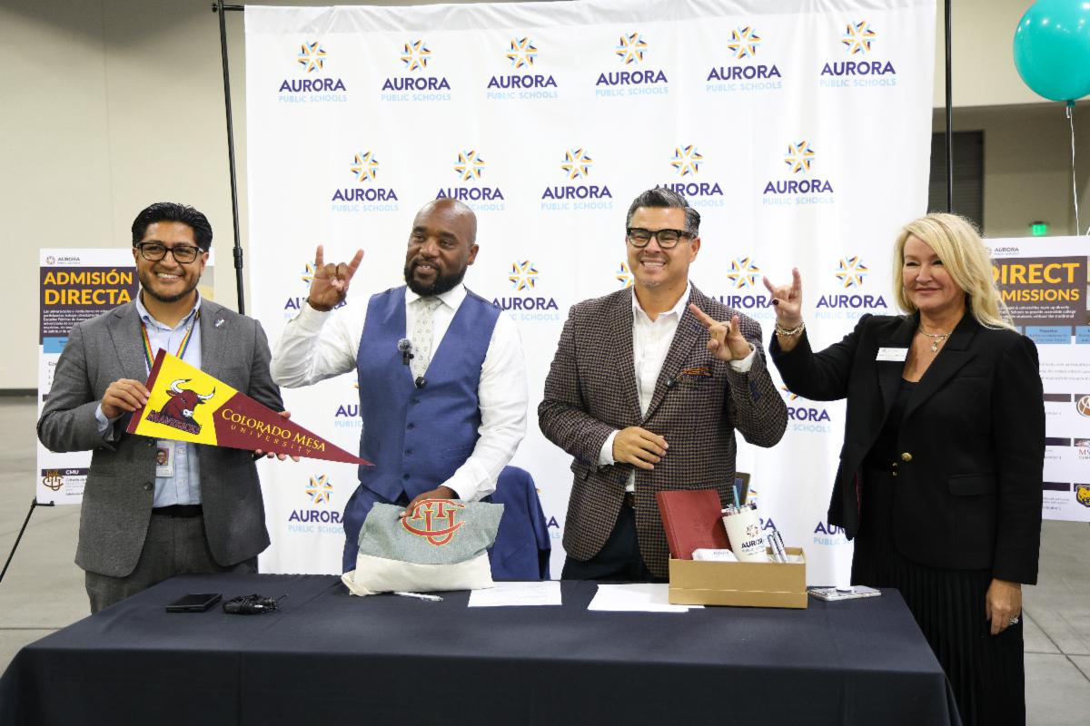 Deputy Superintendent Dr. Jesus Rodriguez, Superintendent Michael Giles, Jr., CMU Senior Vice President Roberto Montoya and CMU Board of Trustees Secretary Kasia Iwaniczko MacLeod signing a Memorandum of Understanding at the APS College Fair.