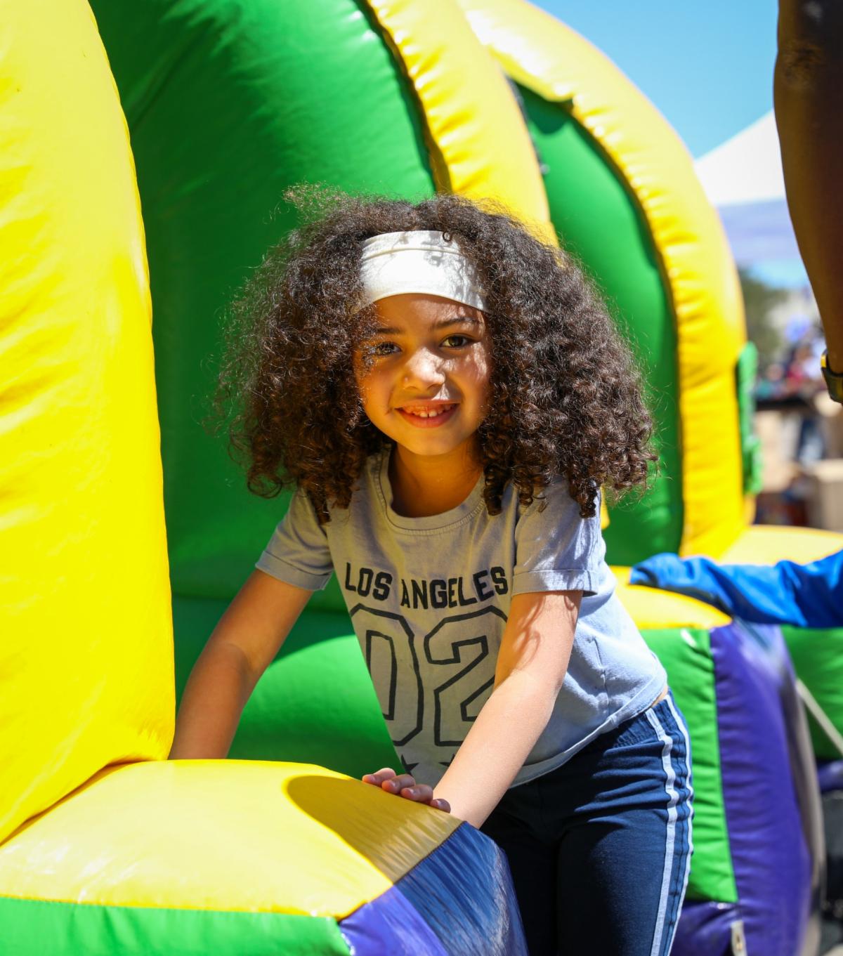 A young student playing in a bouncy castle.
