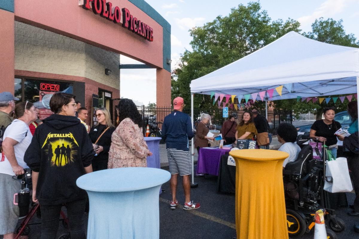 This image of people gathered in front of a businesses with cocktail tables and an event tent links to the Colfax BRT webpage