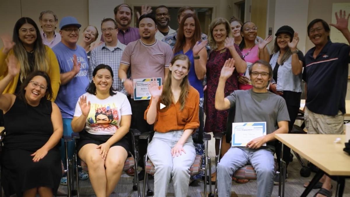 This image of a group of program graduates holding their certificates links to page with more information