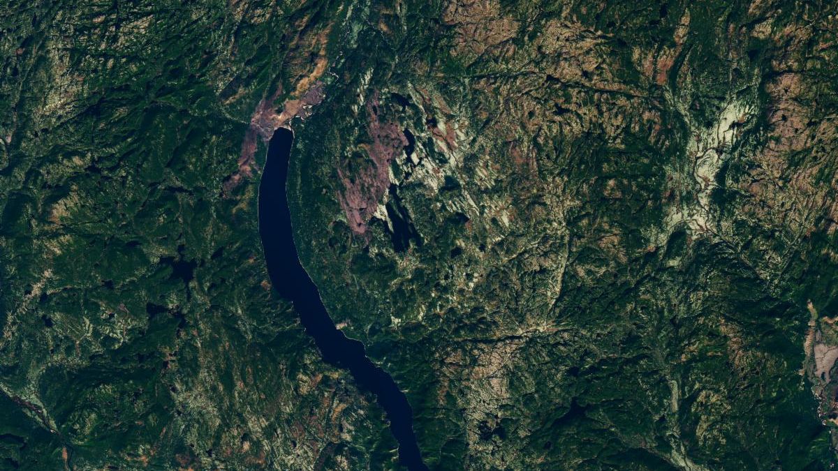 Though subtle, a circular indentation with Lake Marsal near the center is visible in the middle of a mostly green landscape with textured terrain and many lakes.