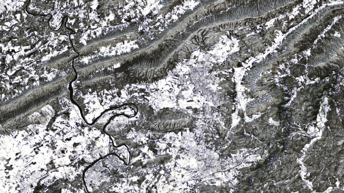 A satellite image of the Appalachian Mountains after a winter snowstorm shows the town of Blacksburg at the center in shades of white and light gray.