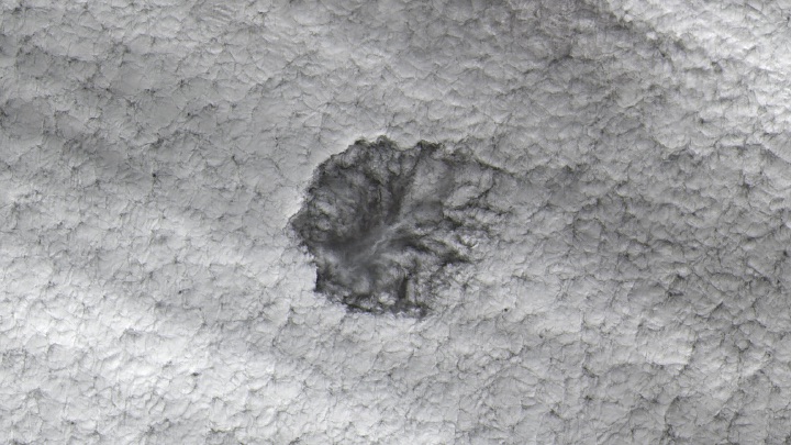 A natural-color Landsat 9 satellite image of a cavum or hole-punch cloud over Wichita, Kansas. This image features a sea of white clouds, with a hole in the middle showing the lower clouds underneath. This image was acquired on December 2, 2024. 