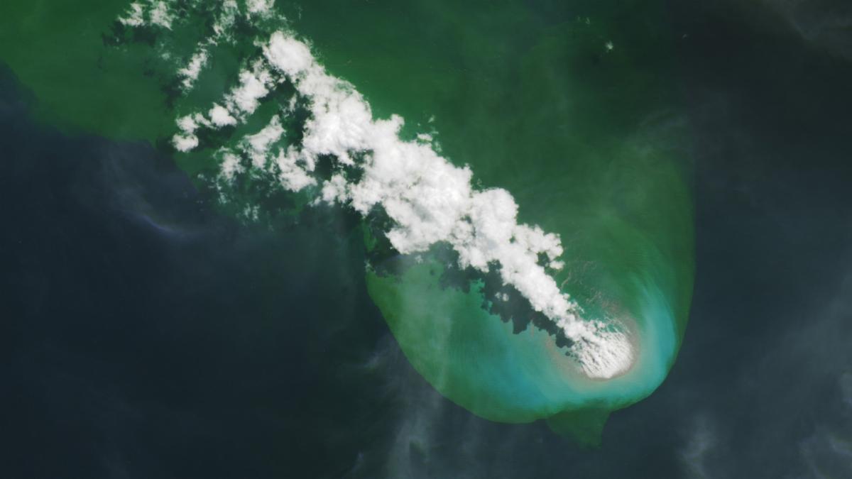 A bright-white volcanic plume and an area of greenish water extend to the northwest from an underwater eruption.