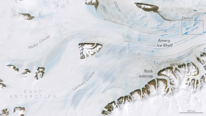 A natural-color Landsat 8 image of an ice shelf in East Antarctica. Text in this image highlights the Mellor Glacier, Fisher Glacier, a detail box, Amery Ice shelf, Rock outcrop, Lambert Glacier, and East Antarctica. Bright white snow blankets most of this image including bright blue spots of melt ponds, with areas of brown rock outcrops surrounding it. This image was acquired on January 1, 2025. 