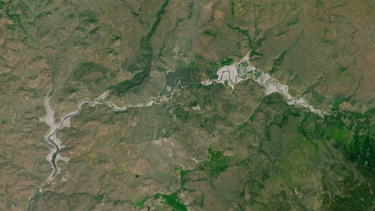 Landsat image of a Klamath reservoir after dam removal. A skinny dark band shows a river surrounded by silty formerly-submerged lands.