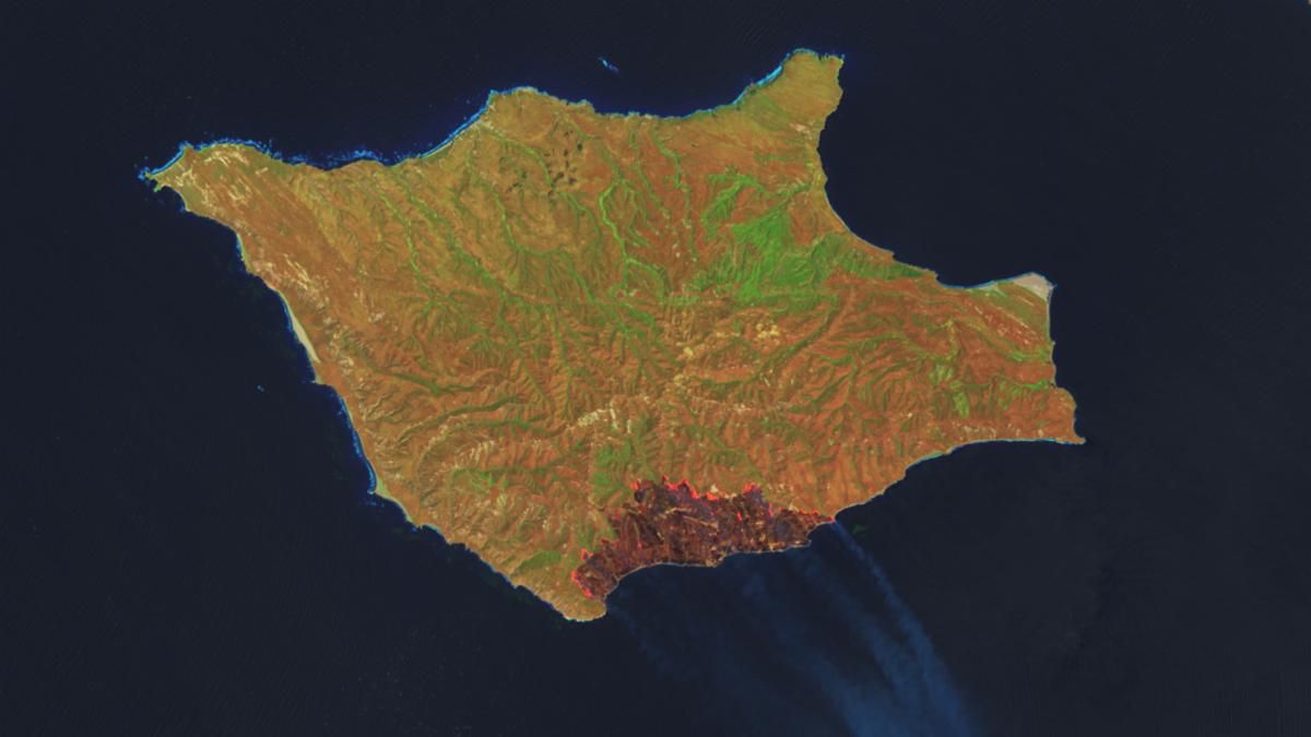 A downward-looking image of Santa Rosa Island shows a dark-brown burned area toward the bottom-right. A thin, bright orange line runs along the burned area, indicating the active fire front.