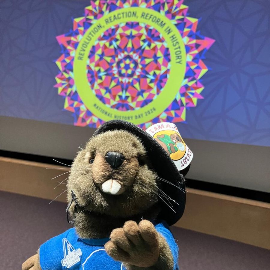 Archie the Jr! Archivist plush beaver celebrates with a festive background.