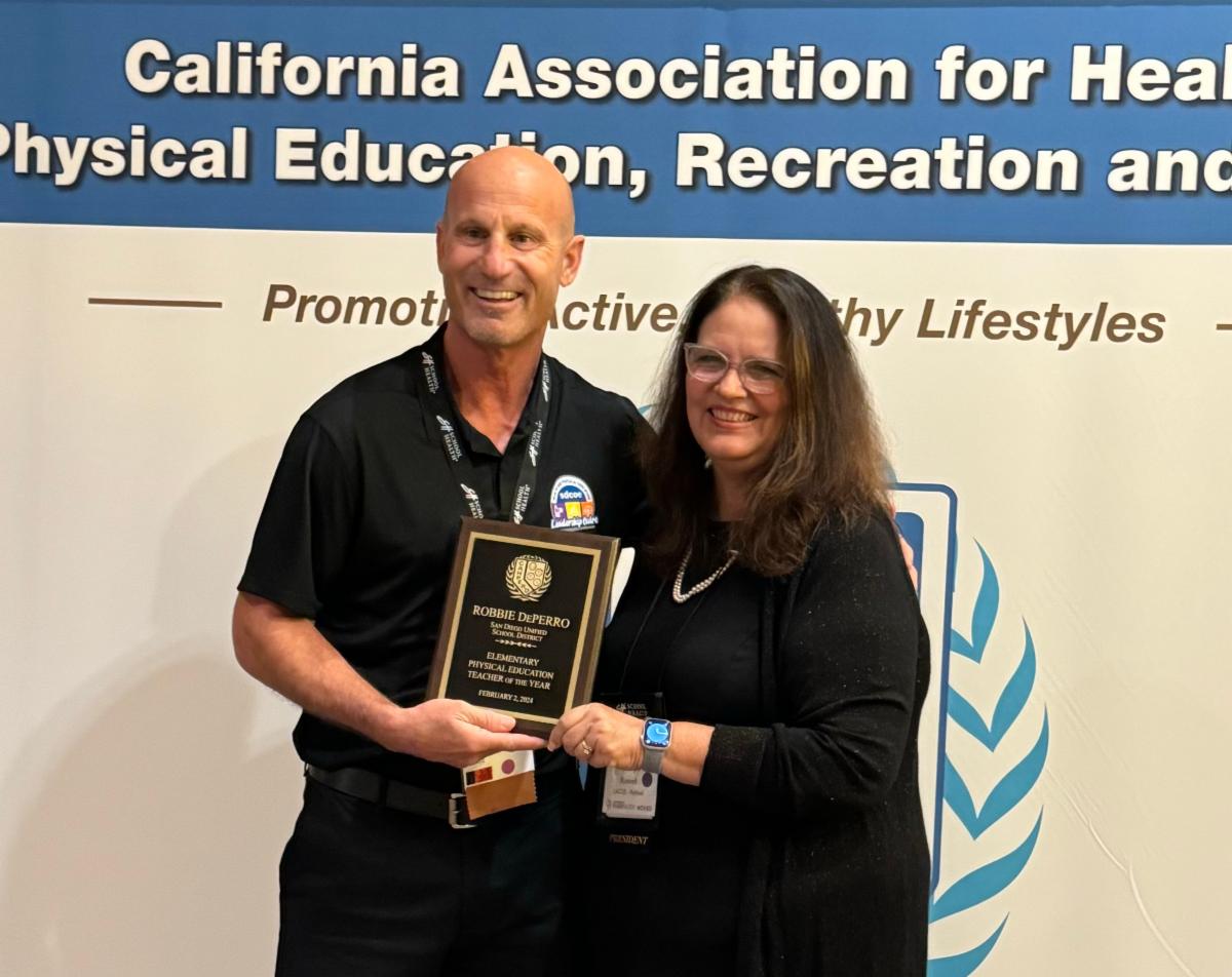Teacher smiling with award