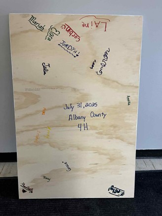signed piece of wood by participants making sensory items for the fair