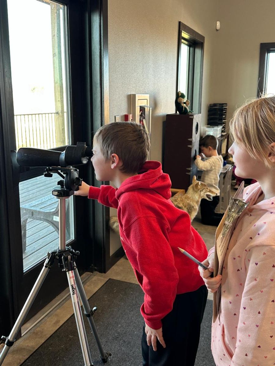 Image of student looking through binoculars at the nature center