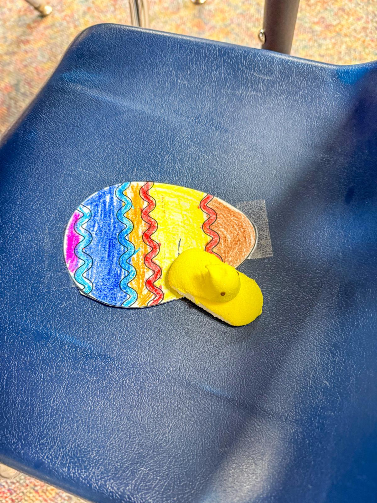 Colored egg with Peep on a students chair. 