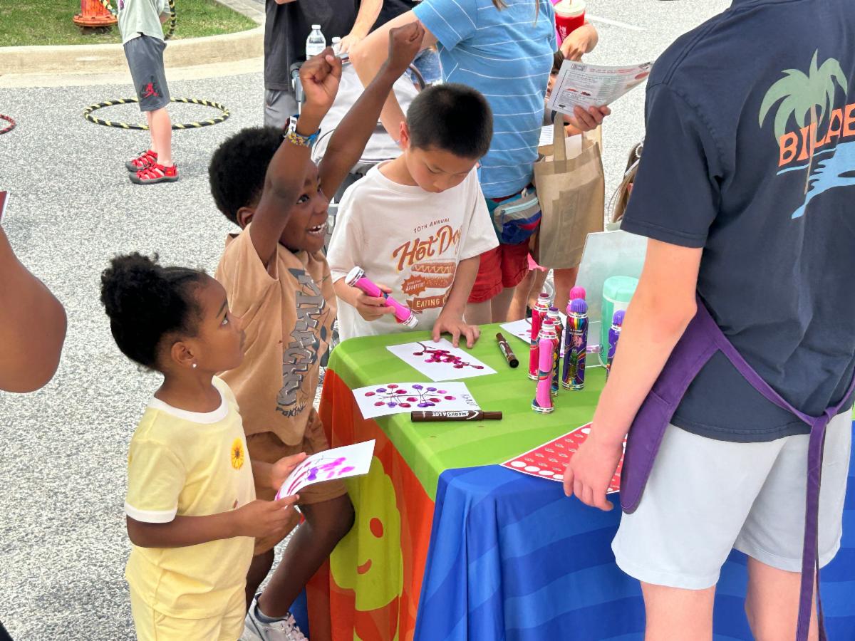 A child lifts his arms and cheers at the Arbutus Library Summer Reading kickoff in June 2026.
