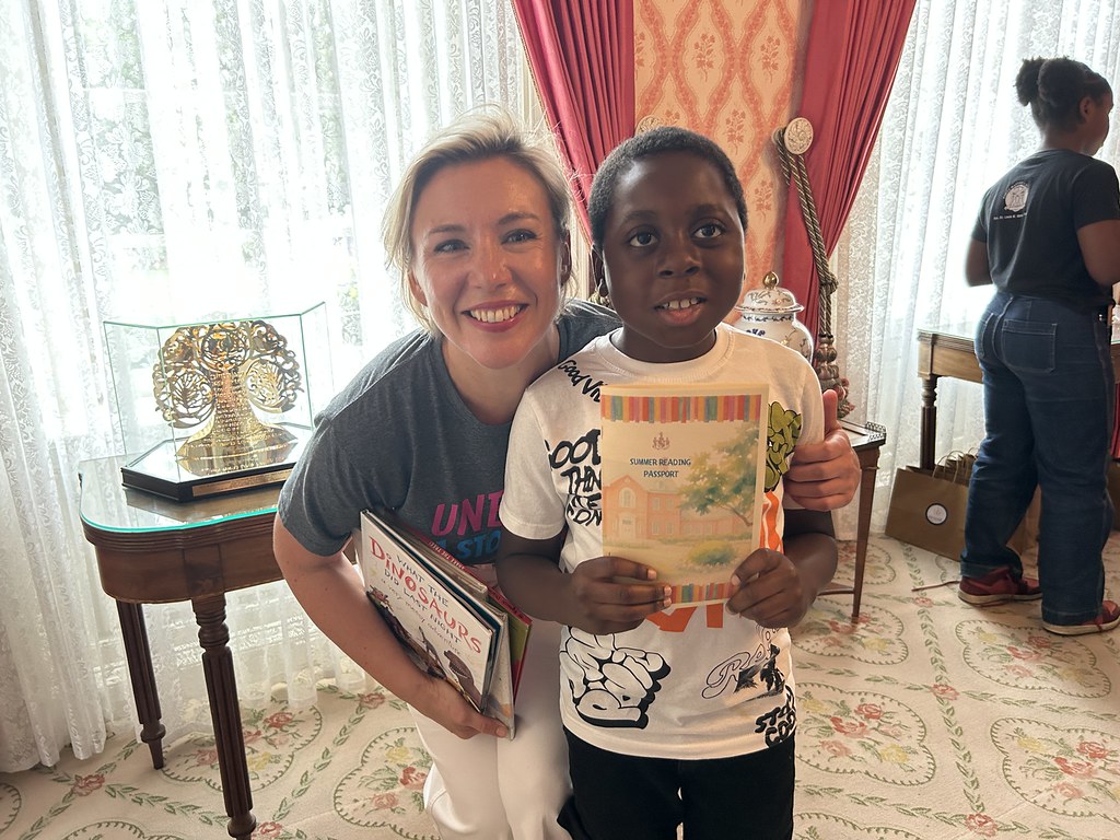 State Librarian Morgan Lehr poses with a child who holds a book at the Governor's Summer Reading Kickoff in June 2026.