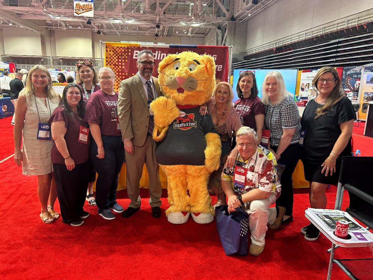 Library leaders pose with Sneaks at MACo 2026.