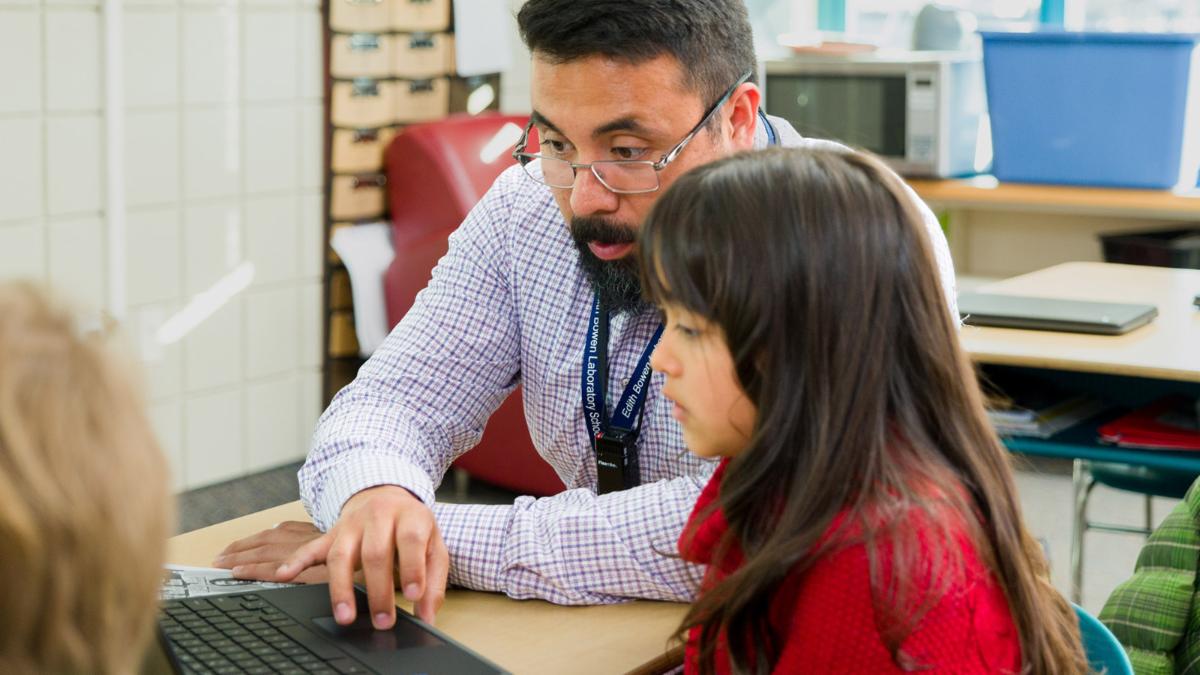 Teacher with young student working together on a computer
