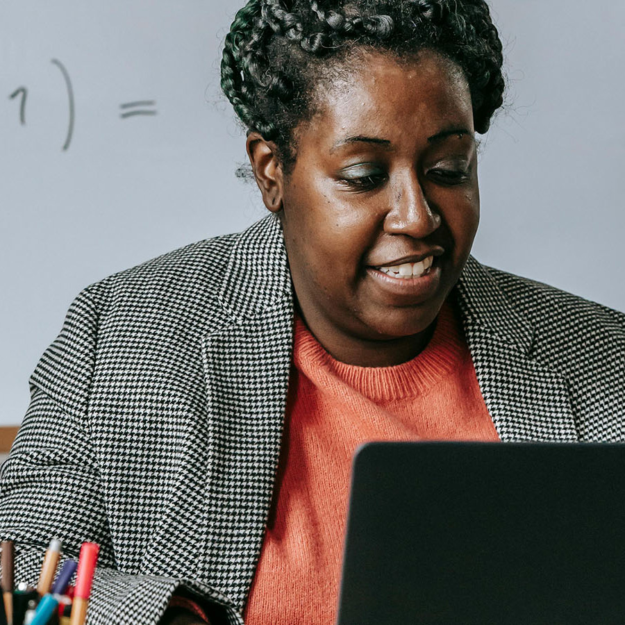 A teacher looks at a laptop