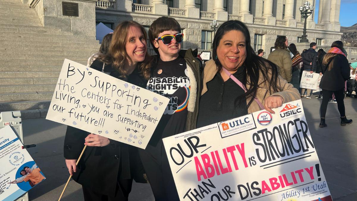marchers hold up signs for disability advocacy day