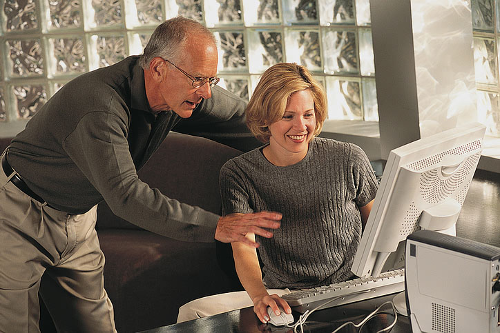 A man and woman looking at a computer screen together