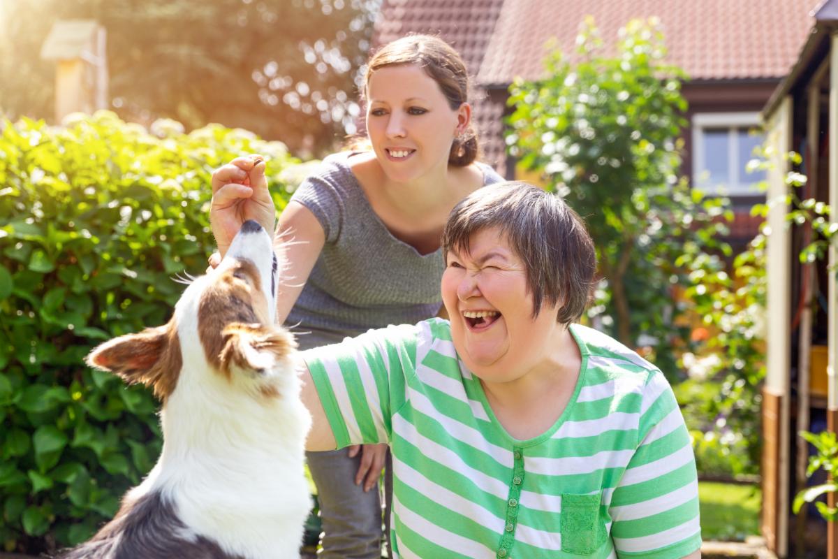 Two women playing with a dog