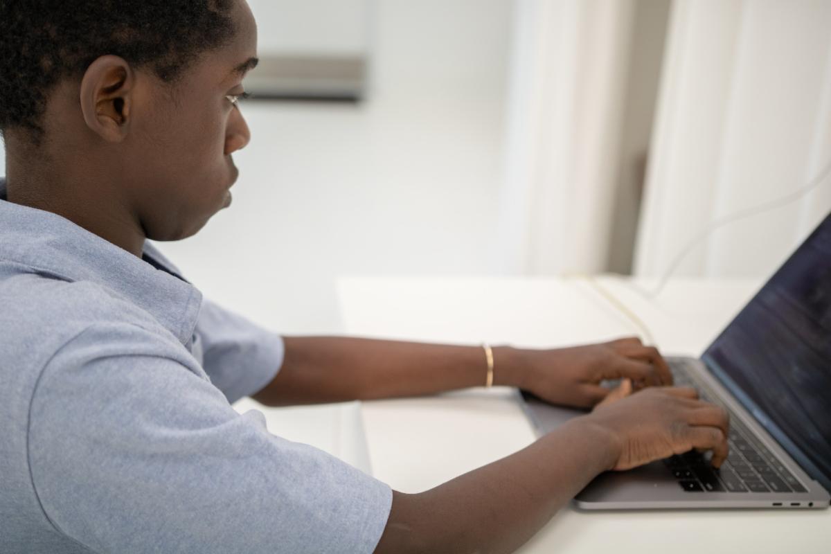 A young man types at a computer
