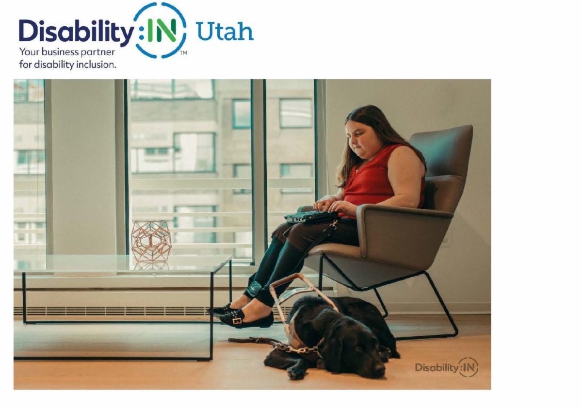 A young woman sits on a chair and uses an assistive device. A dark furred service dog lays next to her. Disability In Utah logo: Your business partner for disability inclusion.