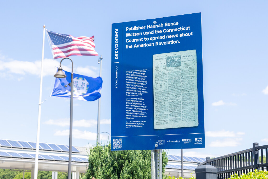 A Connecticut America 250 sign with information about the Hartford Courant sits near a service plaza along Interstate 95 in Milford on Tuesday, June 16, 2026. (Sydney Herdle/UConn Photo)