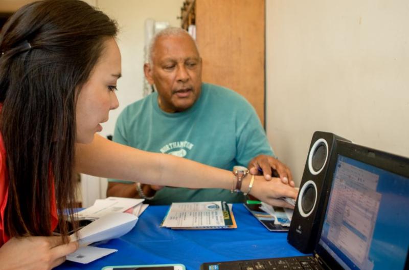 A volunteer assists a visually impaired individual using a computer