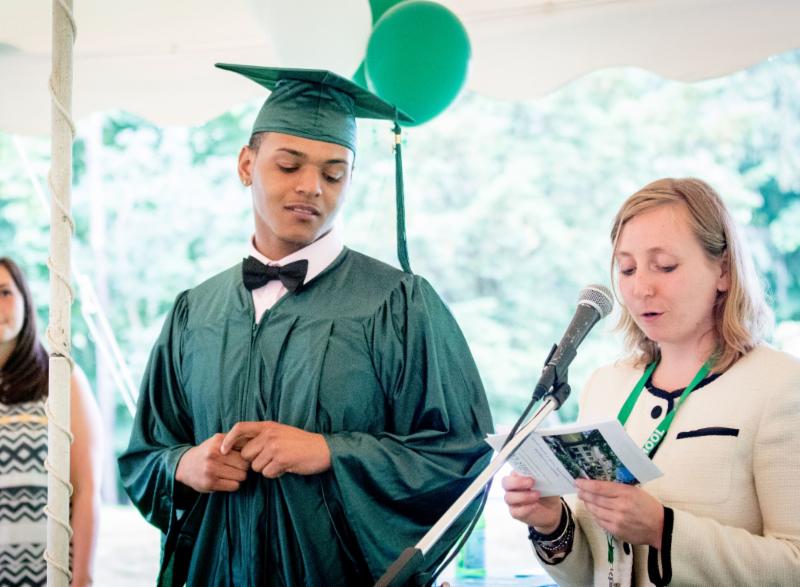 Ivy Street student on the left receiving his diploma from a faculty member on right