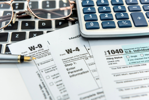 Financial time tax form with laptop and calculator. Office paperwork. Accounting