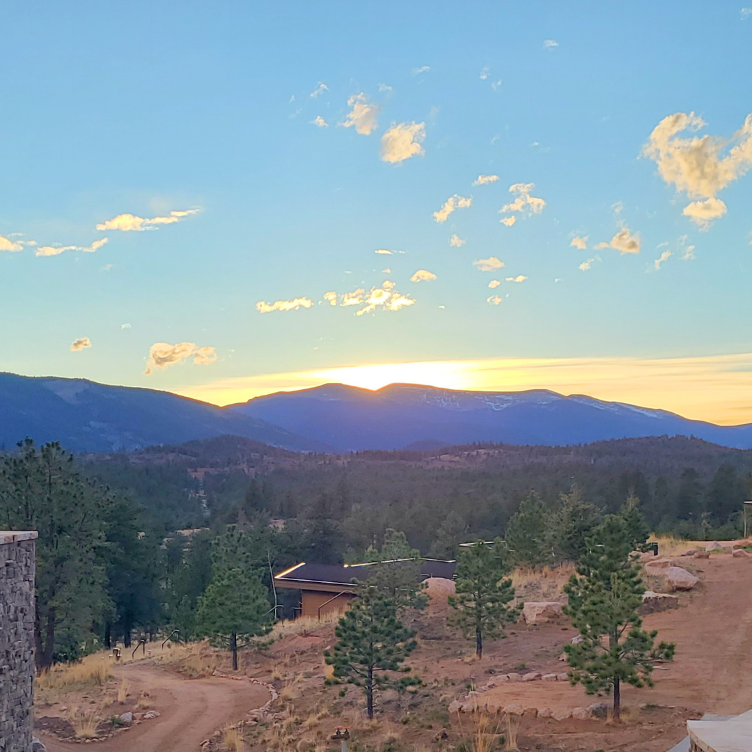 Sun setting behind the mountains at the Lone Rock Retreat Center in Colorado.