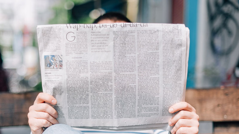 A person reading a newspaper.