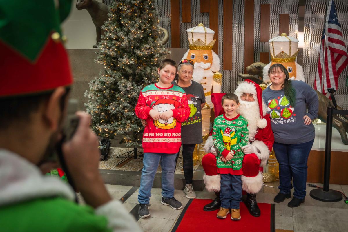 A photo of a family having their photo taken with Santa at STA Plaza