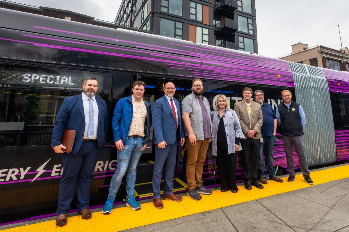 A photo of Susan and others in front of a City Line bus