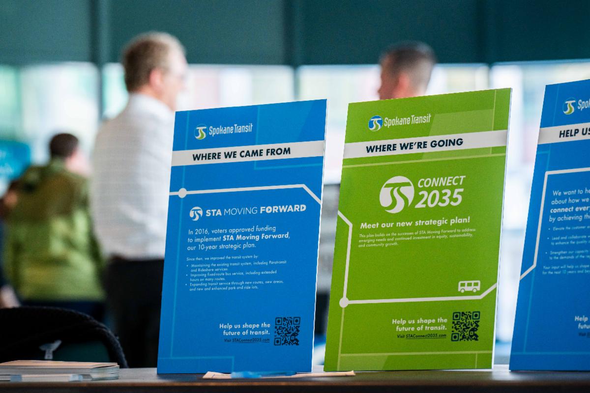 A photo of displays on STA's strategic plans in the foreground and people standing in the background
