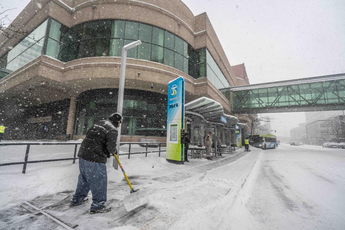 A photo of a facilities crewmember clearing snow at STA Plaza