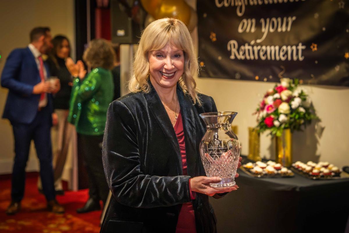 A photo of E. Susan Meyer receiving a crystal vase for her retirement