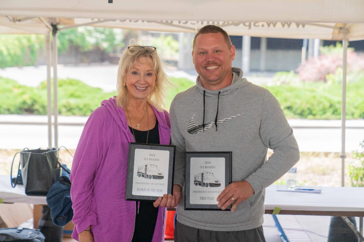 A photo of E. Susan Meyer standing with the Paratransit Roadeo winner