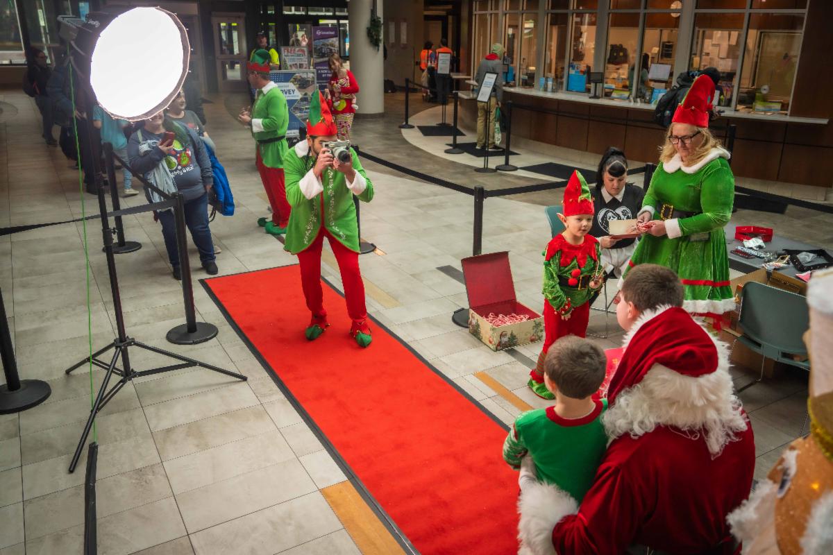 A phot of one of Santa's elves taking a photo of a family