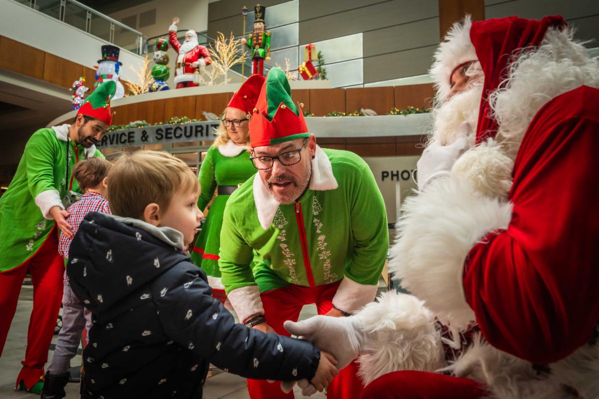 A photo of Santa's elf helping a young boy