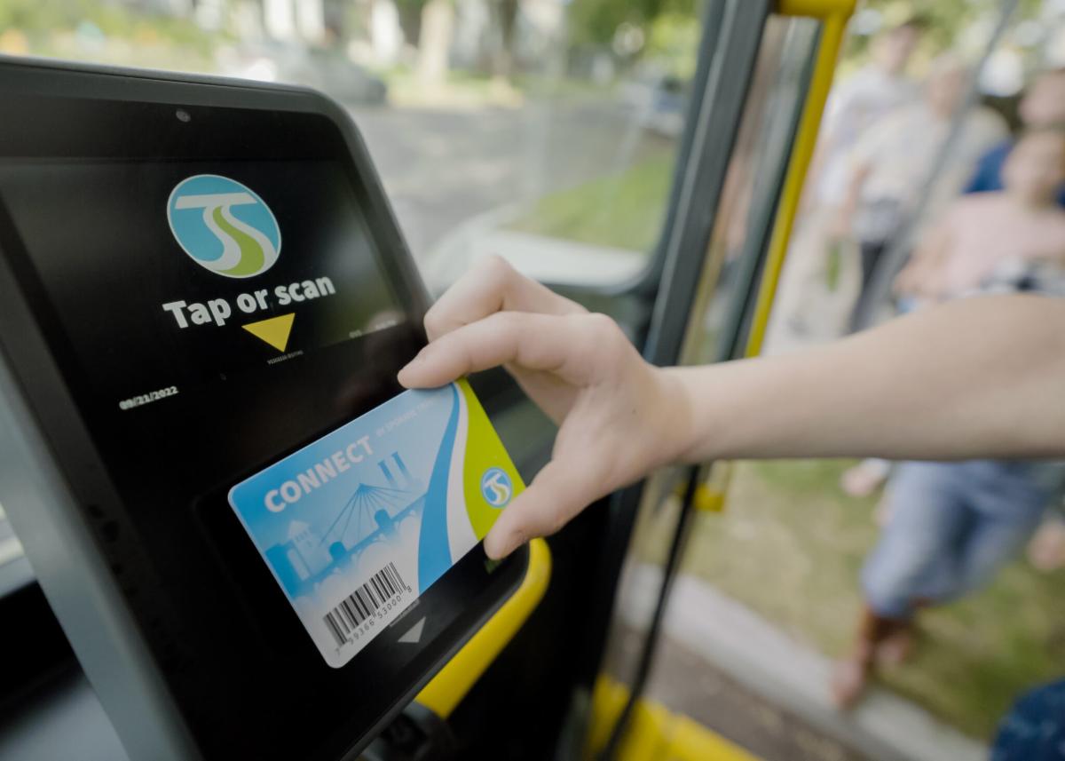 A person taps a Connect card on the fare validator
