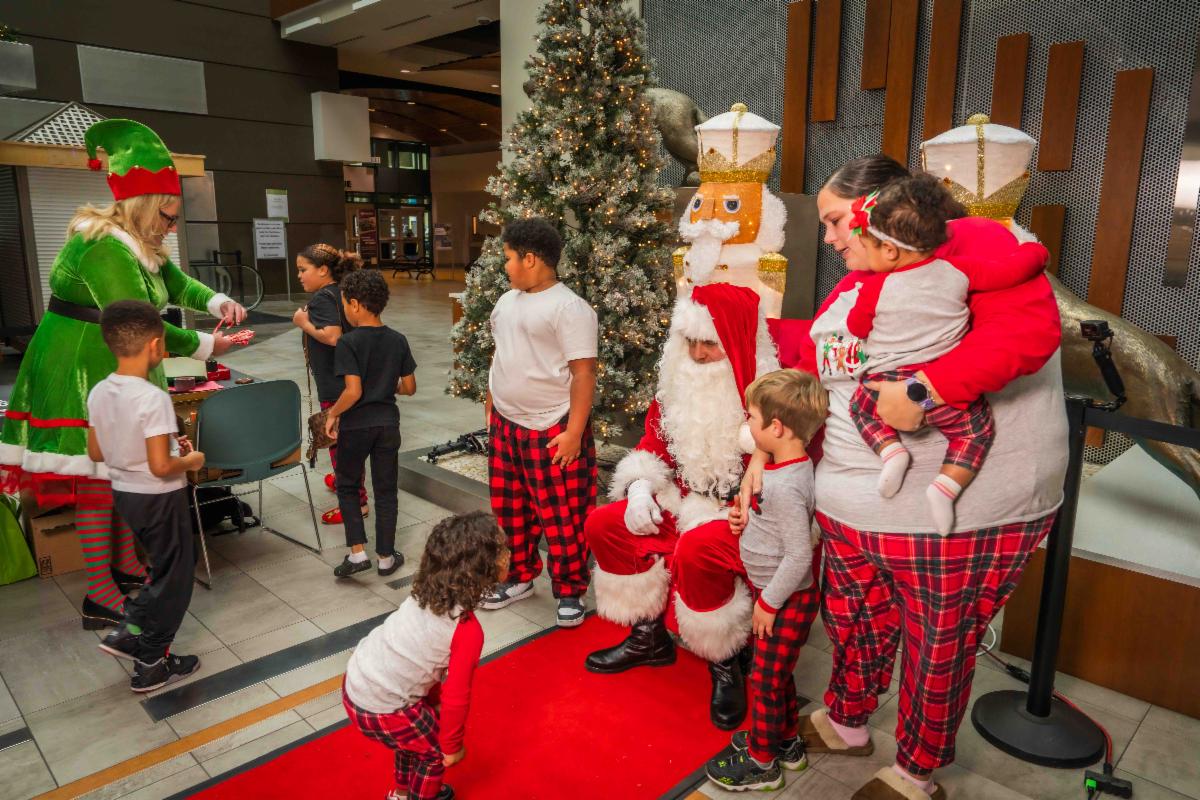 A photo of a family posing for photos with Santa