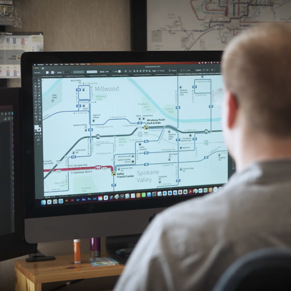 A photo of an STA employee seated at a computer with the system map on display