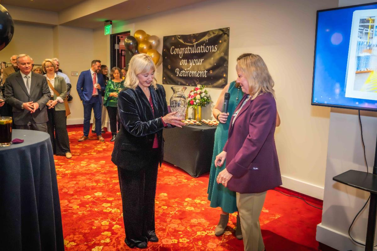 A photo of Spokane Valley Mayor Pam Haley presenting a crystal vase to Susan at her retirement celebration