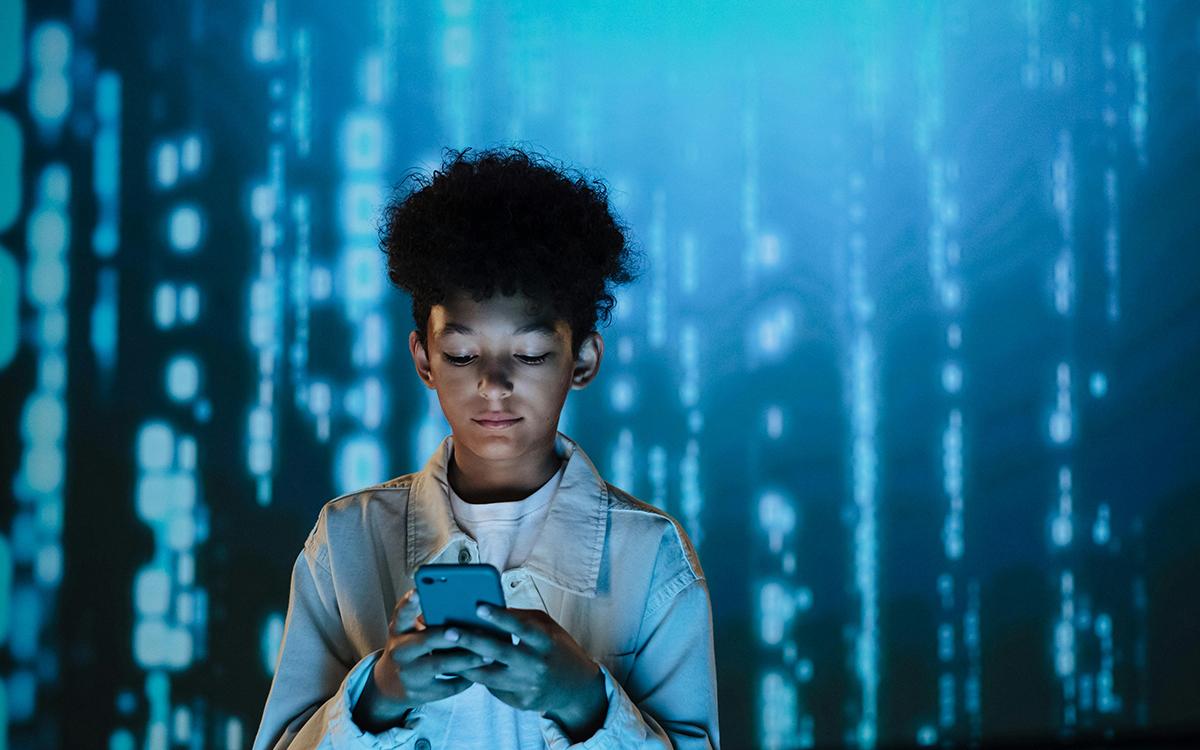 Young person staring into phone screen with techy digital background behind them.