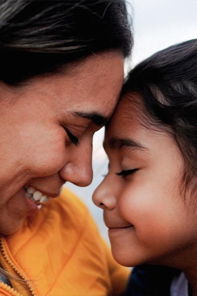 Woman and child putting foreheads together and smiling