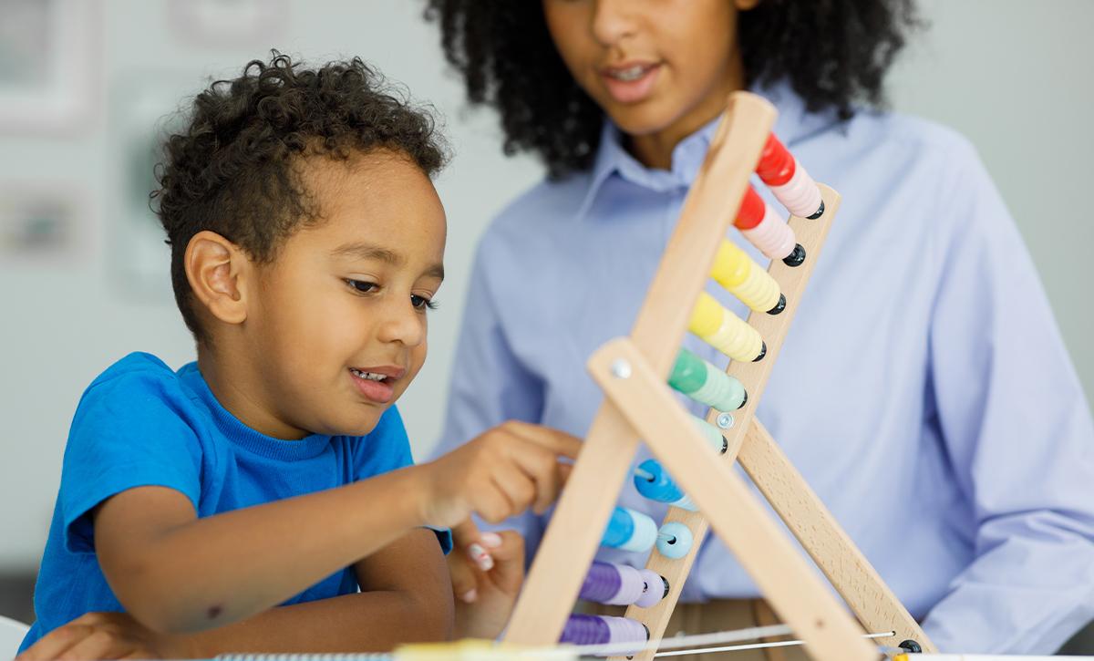 Young child counting on an abacus with an adult