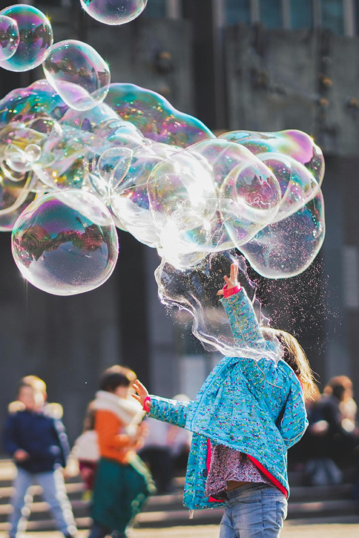 Child playing with bubbles in a park
