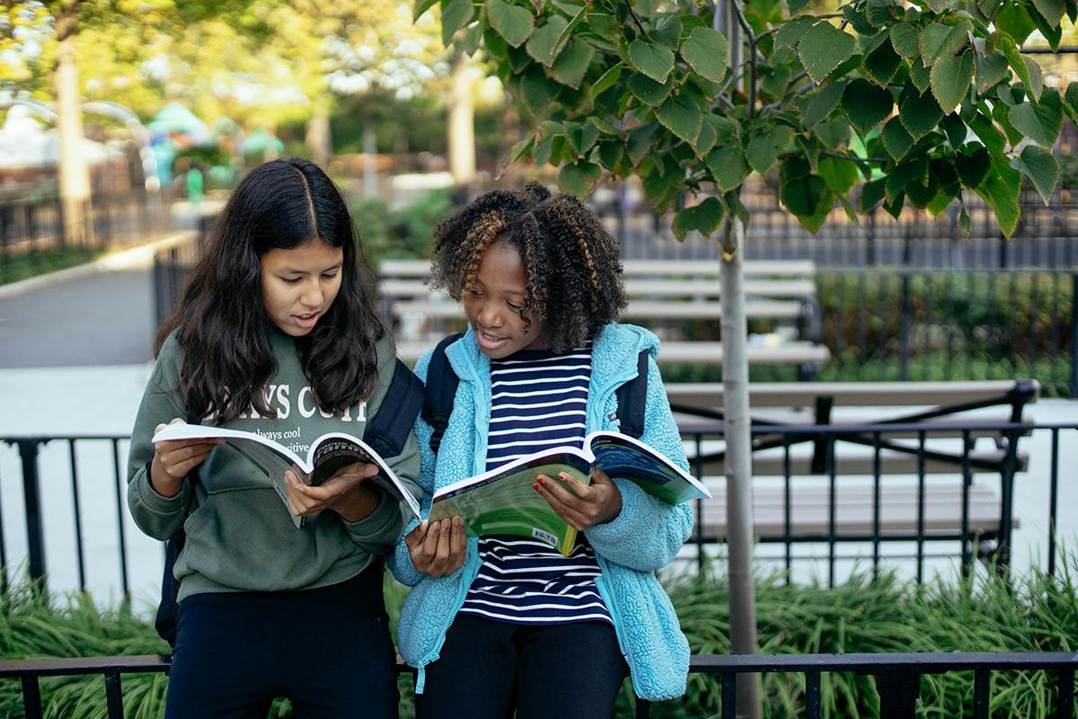 Schoolkids comparing textbooks with each other.